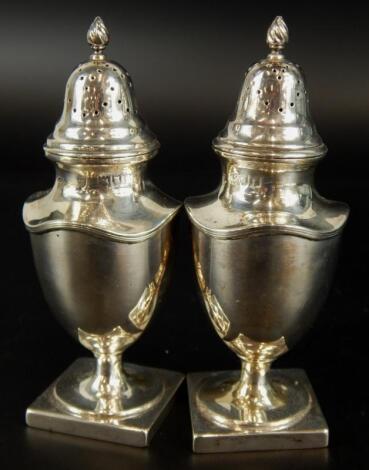 A pair of Edwardian silver pepper pots