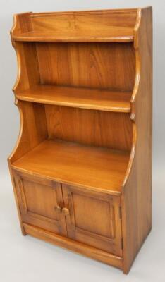 An Ercol type mid coloured elm bookcase