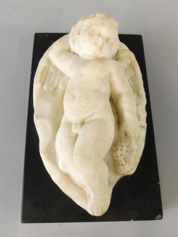 An Italian style carved marble figure of a sleeping putto