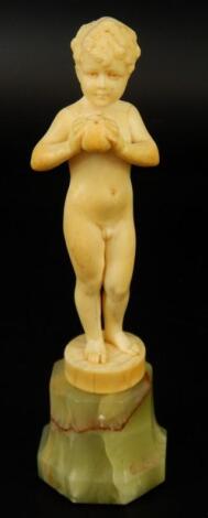 An early 20thC ivory figure of a young boy holding an apple