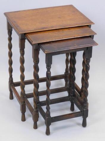 A nest of three early 20thC oak and yew crossbanded tables