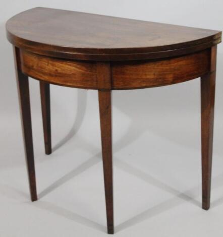 A George III mahogany demi-lune fold over card table