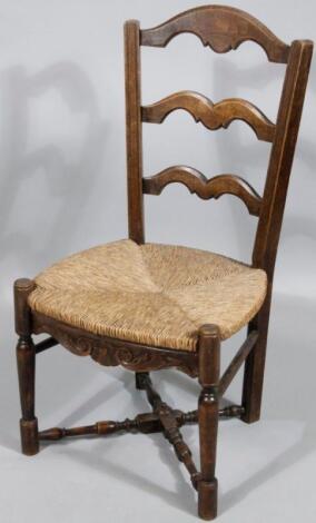 An early 20thC rush seated ladder back chair