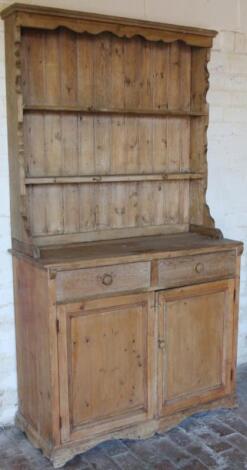 A stripped and lightly polished pine rustic kitchen dresser