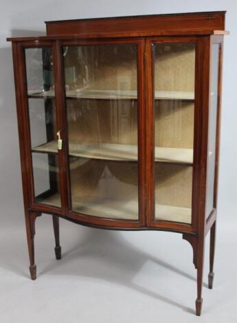 An Edwardian mahogany serpentine fronted display cabinet