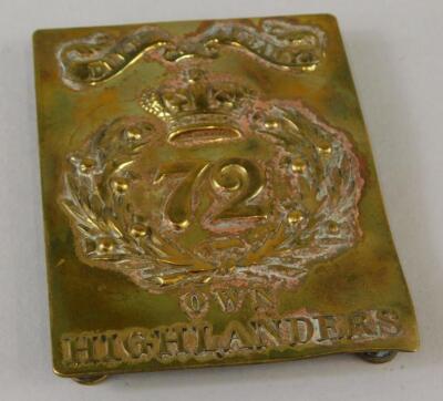 A brass shoulder badge