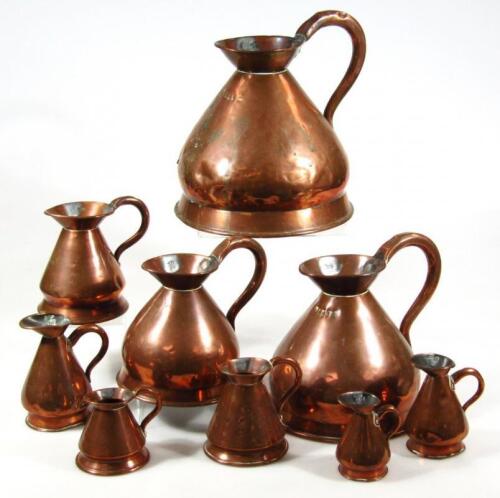 A graduated harlequin set of nine copper harvest jugs