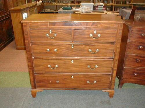 An early 19thC flamed mahogany chest of two short and three long graduated drawers