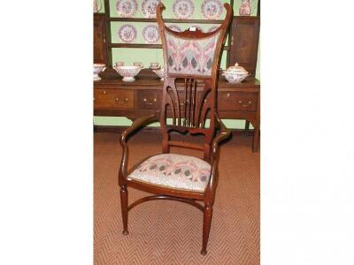 An Art Nouveau mahogany high back elbow chair