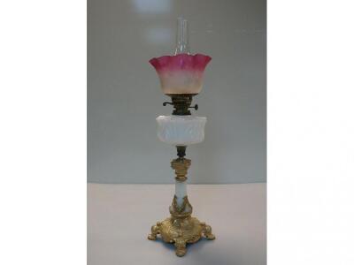 An alabaster and gilt metal oil lamp with moulded milk glass reservoir
