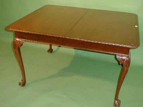 A mahogany pull out dining table with moulded rounded rectangular top and further leaf