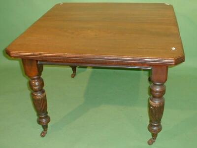 An Edwardian oak extending dining table