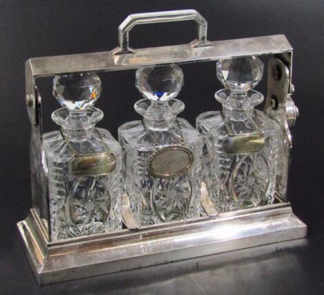 An early 20thC cut glass and chrome plated three bottle tantalus