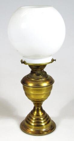 An early 20thC brass milk and clear glass oil lamp