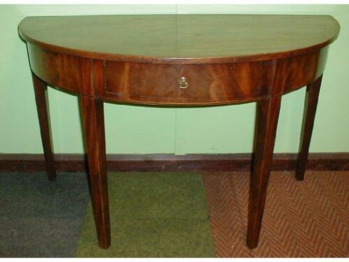 A George III mahogany dining table comprising two D-ends with flamed frieze