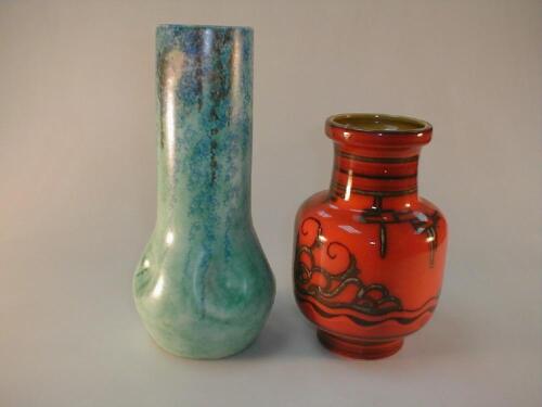 A Gouda pottery vase with abstract scroll decoration to the orange ground