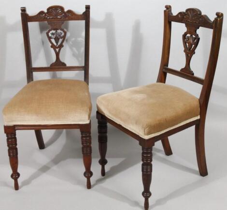 A pair of Edwardian walnut carved armchairs