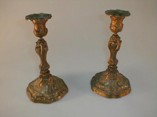 A pair of cast gilt metal candlesticks