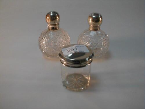 A pair of George V silver topped cut crystal scent bottles London 1919