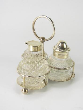 A George V silver and cut glass three piece cruet on stand