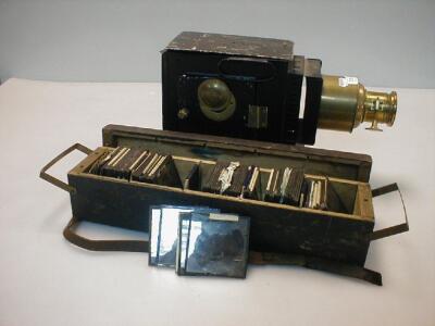 A Victorian brass and tin magic lantern and a case of slides