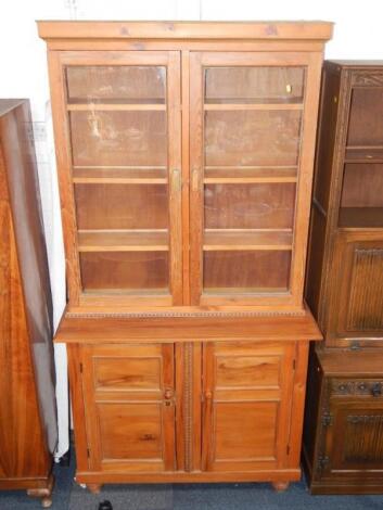 A Victorian and later stripped pine cabinet bookcase