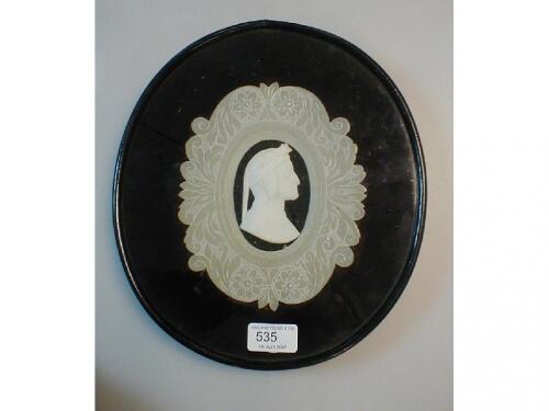 A Victorian oval picture frame with glazed velvet and carved alabaster