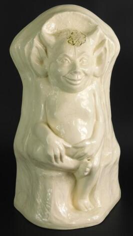 A cream coloured pottery model of a seated Lincoln Imp