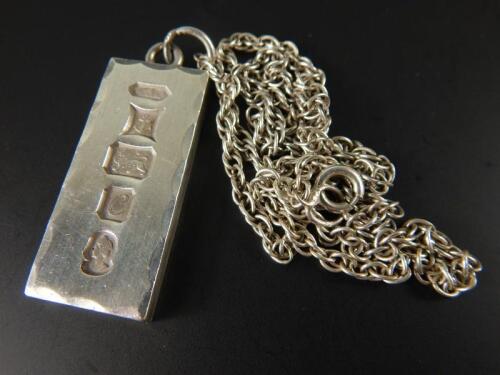 A silver ingot pendant and chain