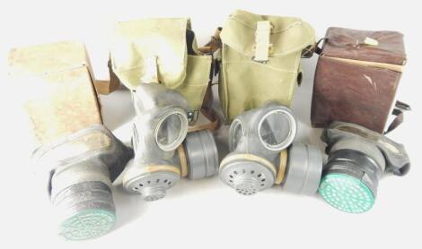 A collection of four military issue gas masks.