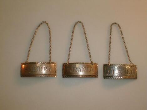 A set of three silver decanter labels of oblong form with gadroon borders