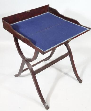 An early 20thC polished mahogany finished campaign folding writing desk