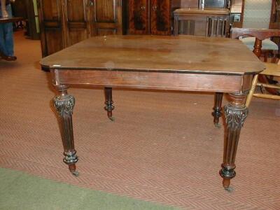 A 19thC mahogany dining table with ebonised and fluted legs