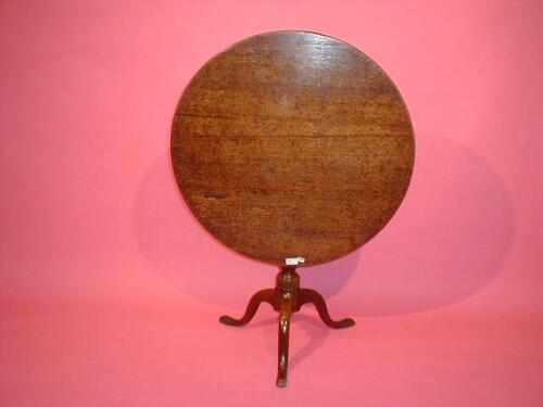 A Georgian oak supper table with circular tilt top and tripod base