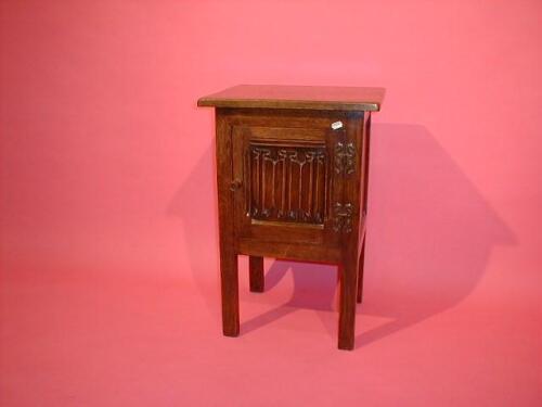 An oak reproduction linen fold pot cupboard