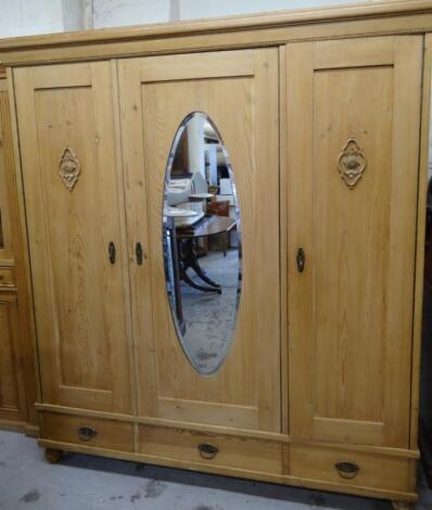 A stripped reclaimed pine triple wardrobe