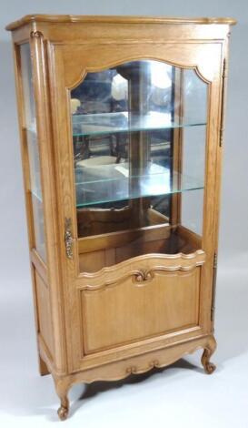 A 20thC light oak display cabinet