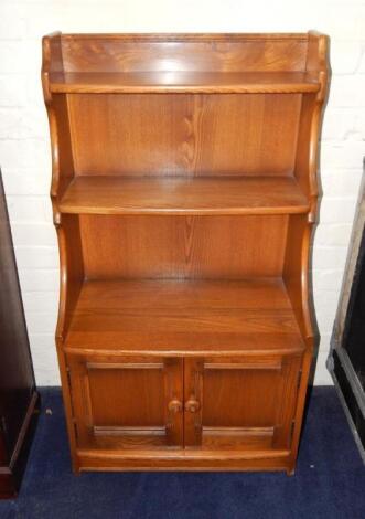 An Ercol light elm waterfall bookcase