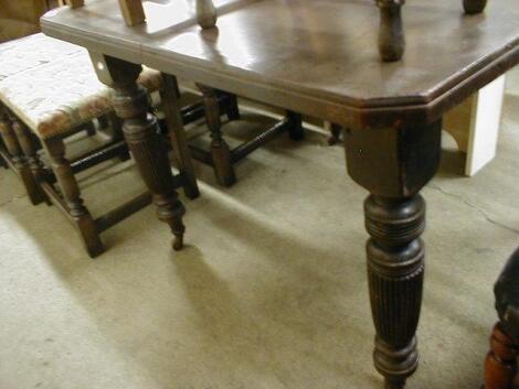 An Edwardian wind-out dining table with reeded legs