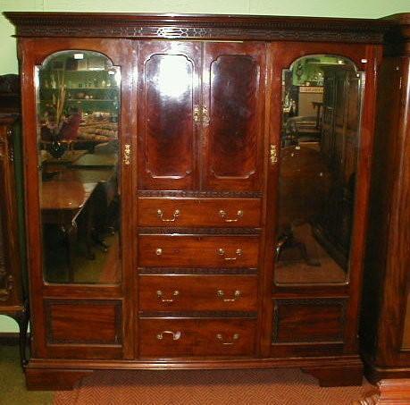 An Edwardian mahogany wardrobe compactum with blind fret dentil moulded