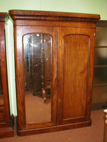 A Victorian mahogany two door wardrobe press with mirror door and panel door