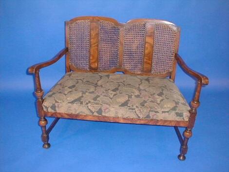 An early 20thC walnut finish two seater open sofa with caned back