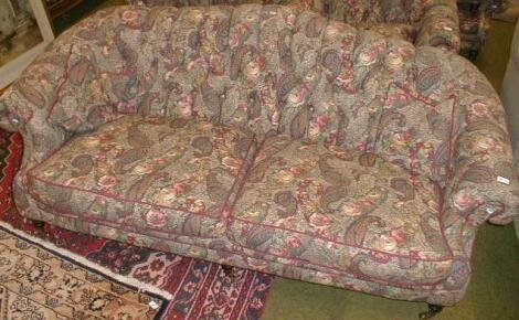 A Victorian style three seater scroll arm sofa in paisley upholstery