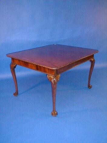 A mahogany pull out dining table with moulded rounded rectangular top and further leaf