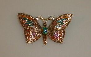 A yellow metal and faux opal set butterfly brooch