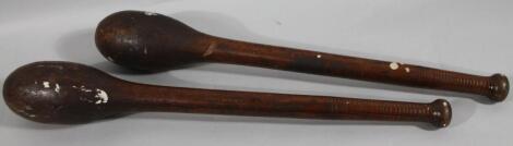 A pair of 19thC stained wooden exercise clubs