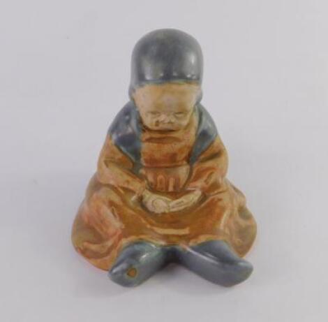 An early 20thC Quimper figure of a seated child