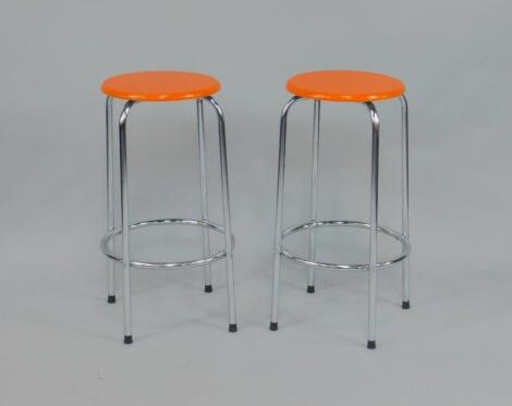 A pair of mid 20thC orange painted wooden and aluminium kitchen stools