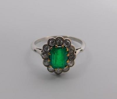 An emerald ring in a surround of diamonds