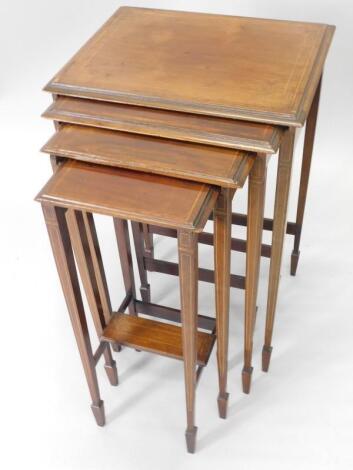 An Edwardian mahogany and satinwood crossbanded nest of four tables